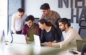 Ein engagiertes Team junger Fachkräfte arbeitet gemeinsam an Laptops in einem modernen Büro – ein typisches Beispiel für die kreative und kollaborative Arbeitsweise in deutschen Startups.