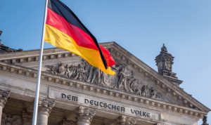 Die deutsche Flagge weht vor dem Reichstagsgebäude in Berlin mit der Inschrift „Dem Deutschen Volke“ – Symbolbild für Stabilität, Staat und Bundesanleihen als sichere Form der Geldanlage.