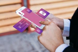 Eine Person nutzt ein Smartphone mit digital eingeblendeten Benutzeroberflächen und Finanzsymbolen – Symbolbild für moderne Finanztechnologien und die wachsende Bedeutung von Fintechs im digitalen Bankwesen.