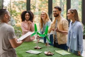 Gruppe junger Unternehmer diskutiert über Windkraftmodelle im Büro, Symbol für Innovation und nachhaltige Ideen von Grüne Startups.